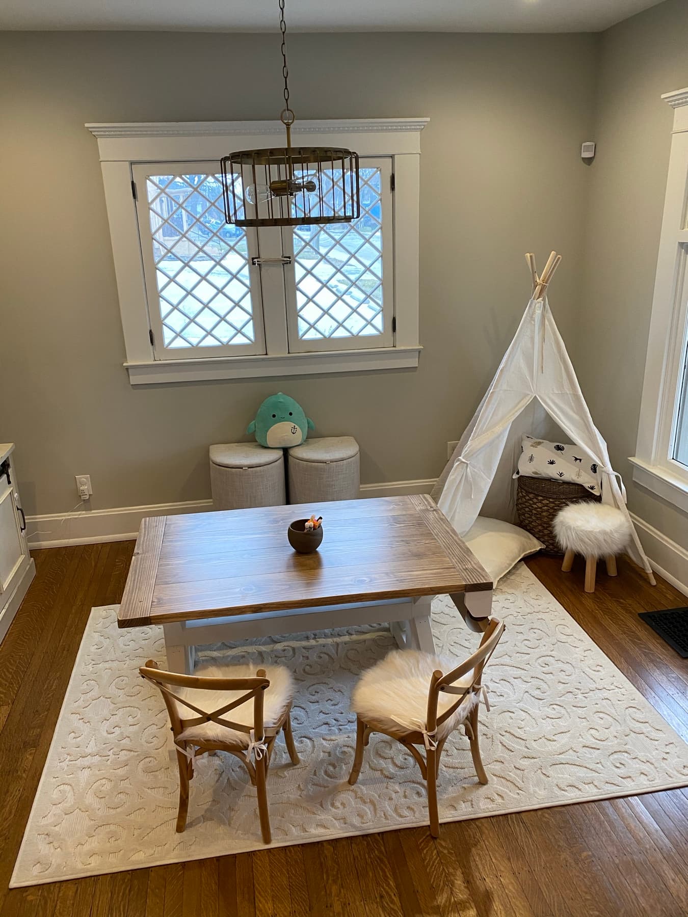 A kids' play room styled in calm neutrals with organized, accessible storage.